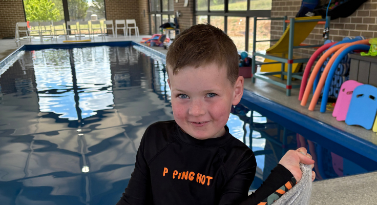 A young student in swimmers ready for swimming lessons